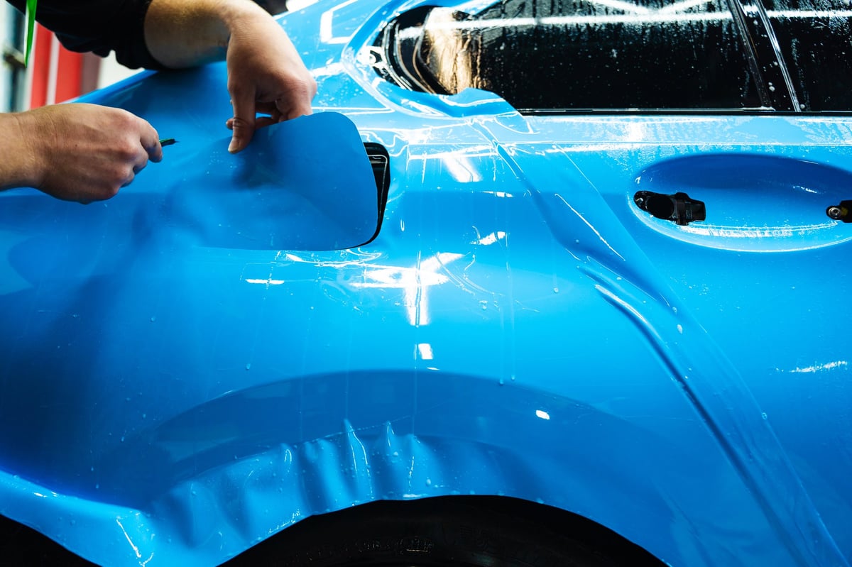 Blue PPF trimming on car panel